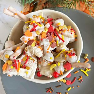A bowl of almond bark cereal dessert with sprinkles in it.
