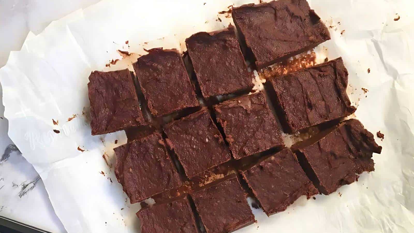 Fifteen pieces of chocolate fudge arranged on white parchment paper.