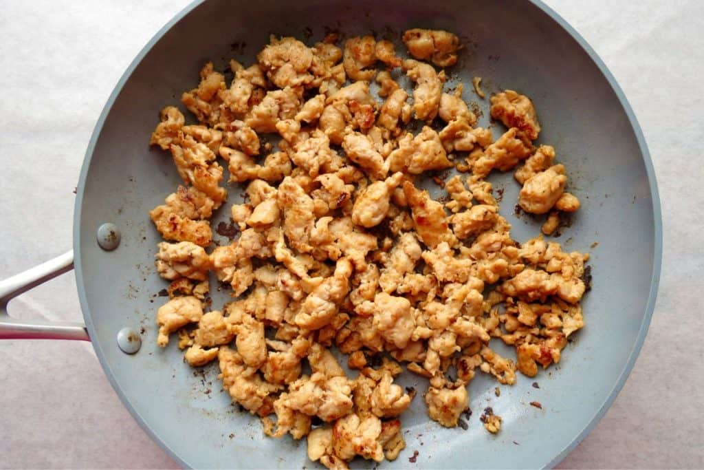 Cooked ground chicken in a gray frying pan.