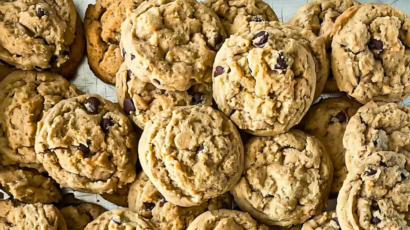 A pile of homemade oatmeal chocolate chip cookies on a wire cooling rack.