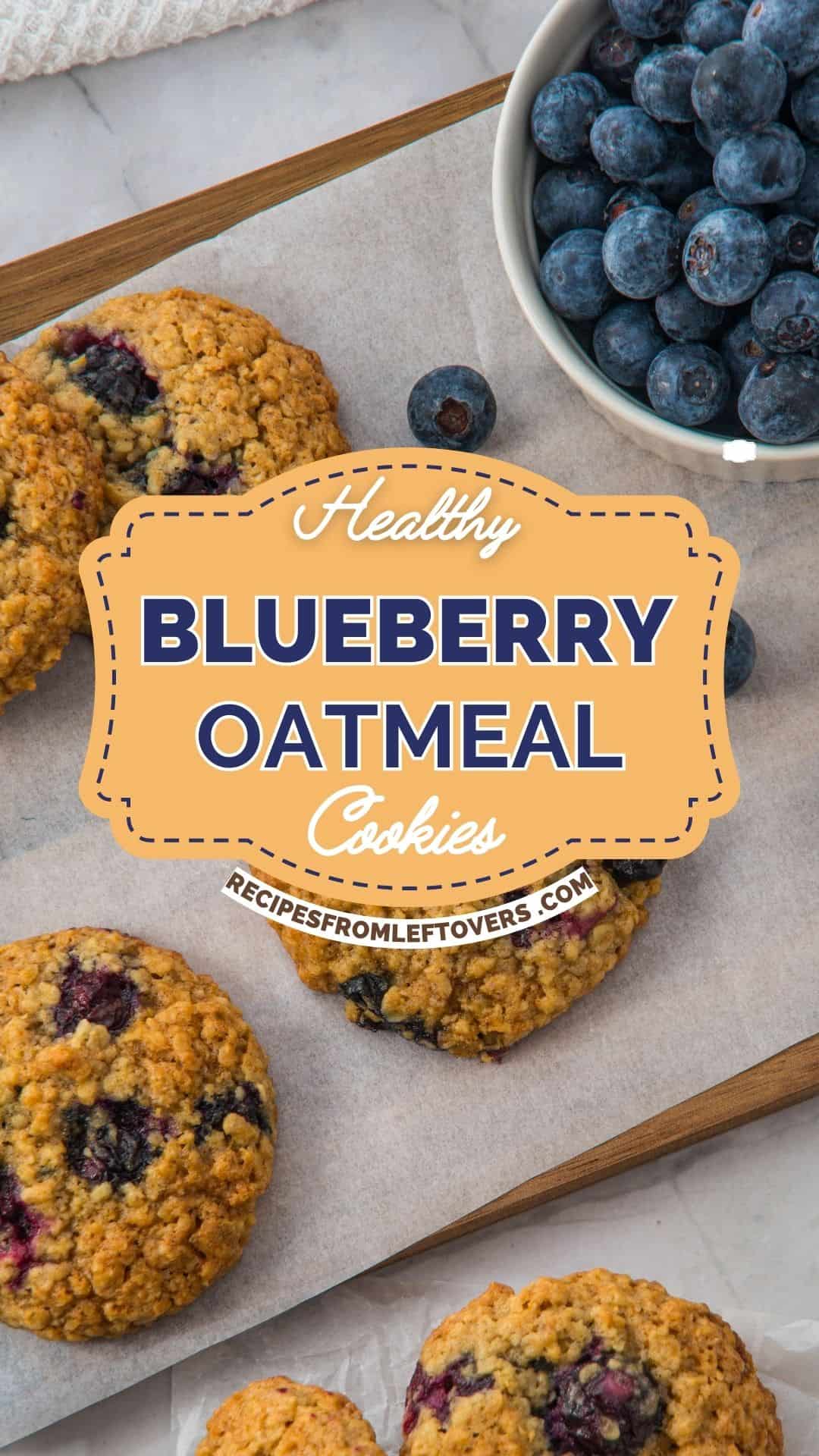 Four blueberry oatmeal cookies on parchment paper and a bowl of fresh blueberries on a wooden board, with a label reading "Healthy Blueberry Oatmeal Cookies.