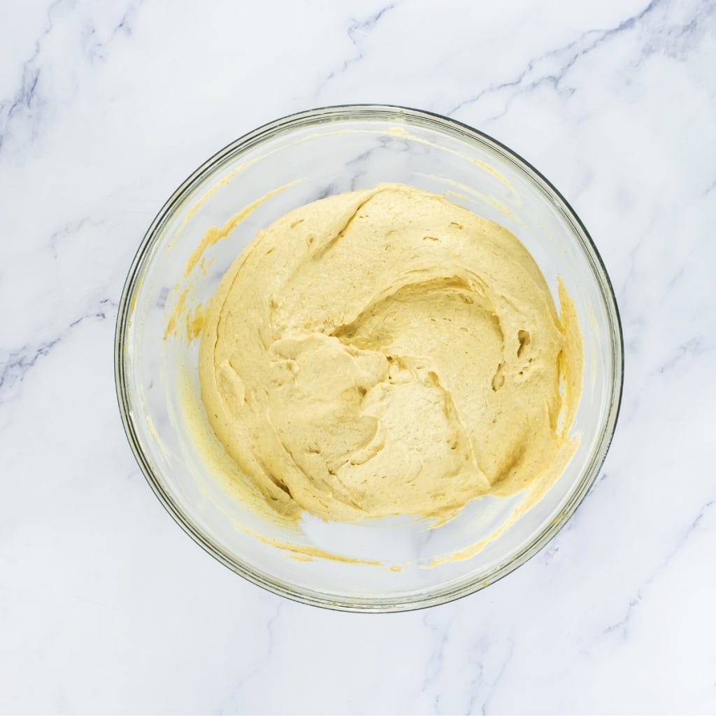 A glass bowl filled with smooth, light mix for no bake pumpkin pie.